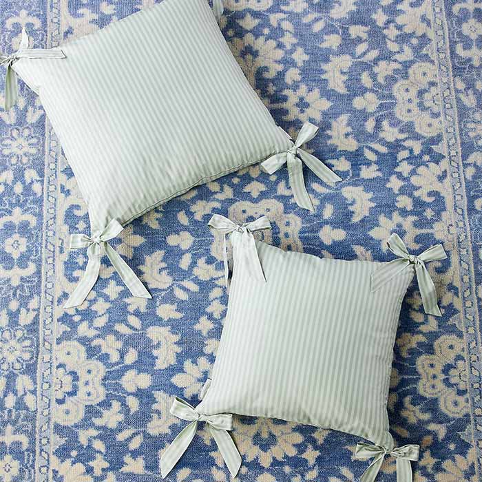 Noelle Bow Pillows in Wintergreen on Rug