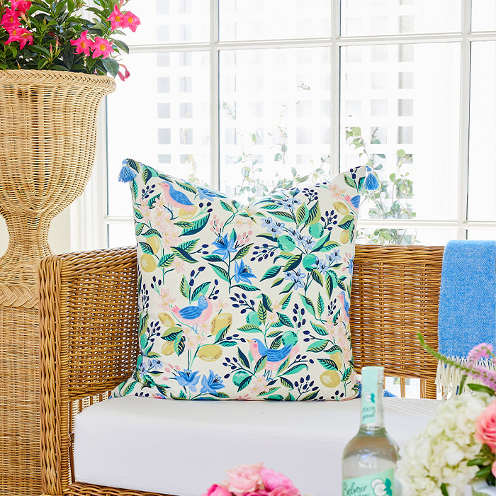 Floral Pillow on Wicker Sofa with Woven Planter and Flowers