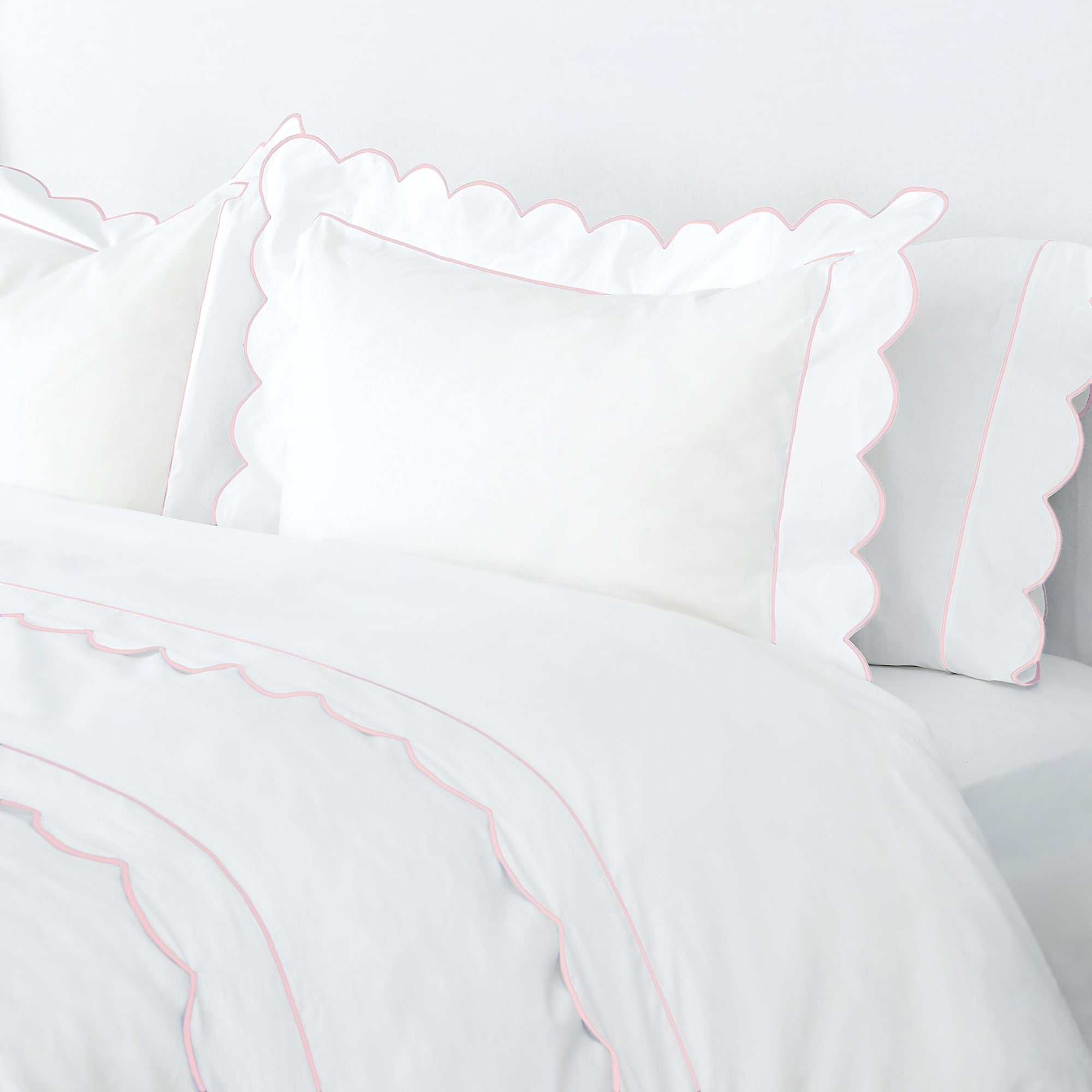 Pink Butterfield Matouk Sheets with Scalloped Edge on Bed