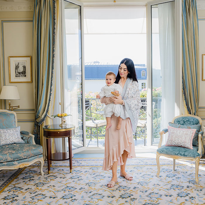 Caitlin Wilson wearing Toile de Jouy Blue Print Shawl holding Baby